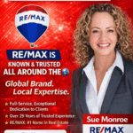 Smiling woman beside RE/MAX real estate ad